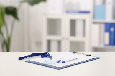 Photo of Clipboard with paperwork and badge on desk in doctor's office. Space for text