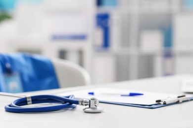 Photo of Stethoscope and paperwork on desk in doctor's office. Space for text