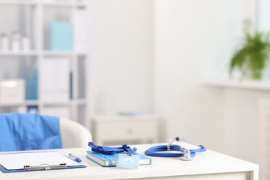 Photo of Doctor's workplace with stethoscope and paperwork on desk. Space for text