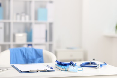 Photo of Doctor's workplace with stethoscope and paperwork on desk. Space for text