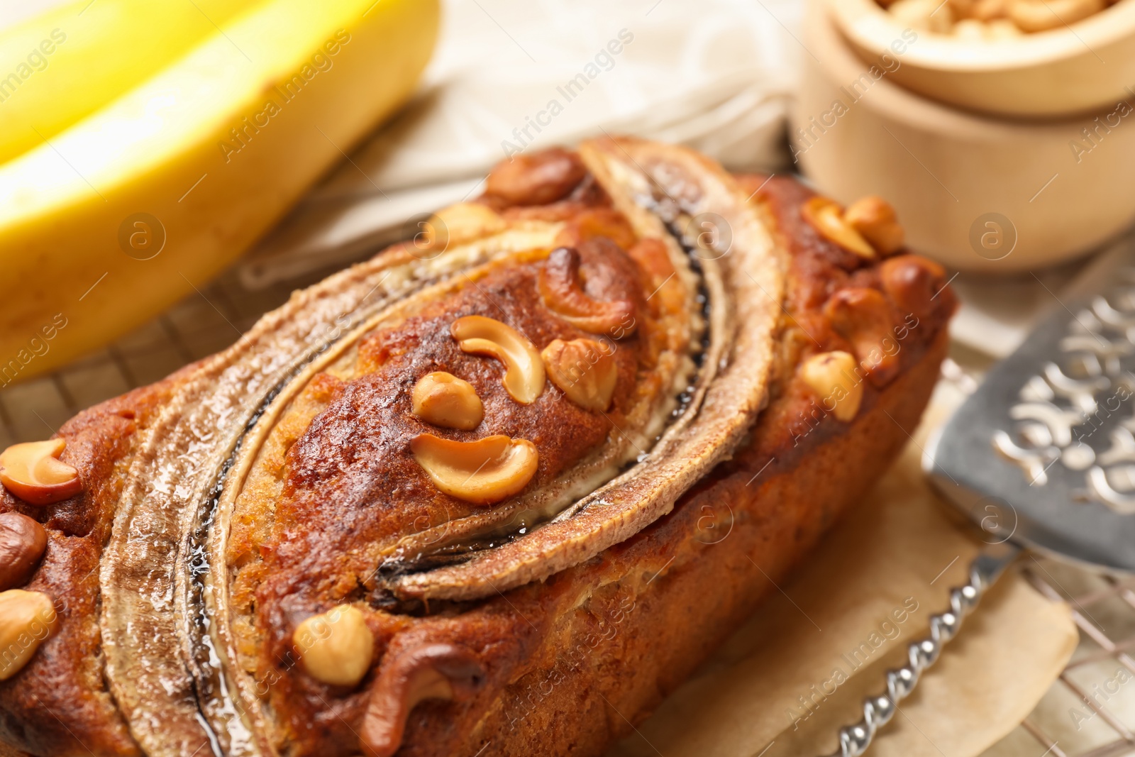 Delicious banana bread with nuts on light table, closeup Photo of Delicious banana bread with nuts on light table, closeup