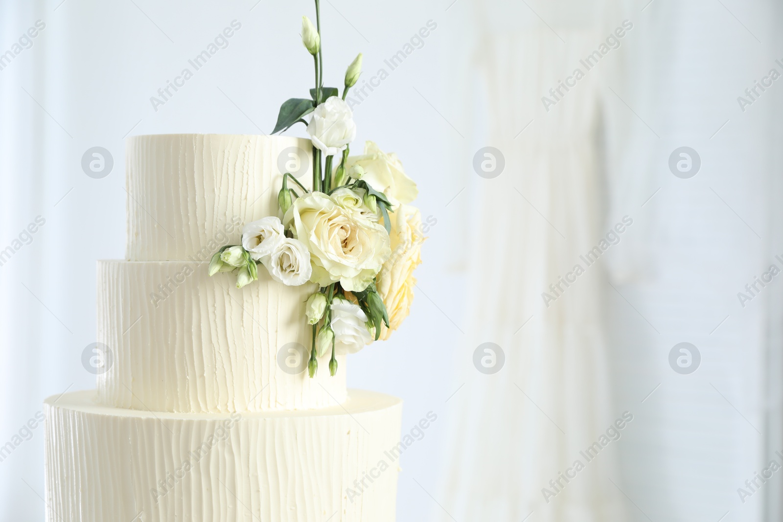 Delicious wedding cake with floral decor indoors, closeup. Space for text Photo of Delicious wedding cake with floral decor indoors, closeup. Space for text