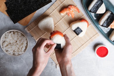 Photo of Woman making onigiri (Japanese rice balls) at light table, top view