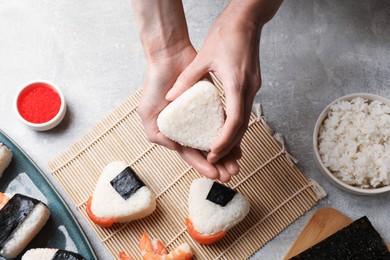 Photo of Woman making onigiri (Japanese rice balls) at light table, top view