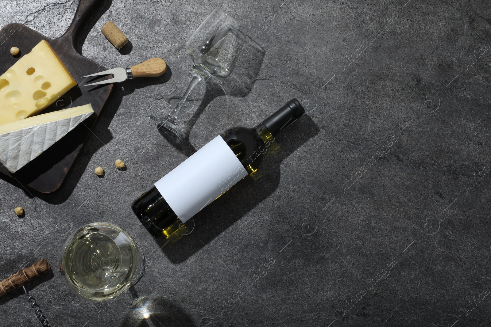 Tasty wine, cheese and nuts on grey background, flat lay. Space for text Photo of Tasty wine, cheese and nuts on grey background, flat lay. Space for text
