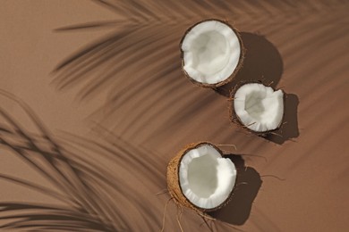 Photo of Fresh coconut and shadow cast by tropical palm on beige background, flat lay. Space for text
