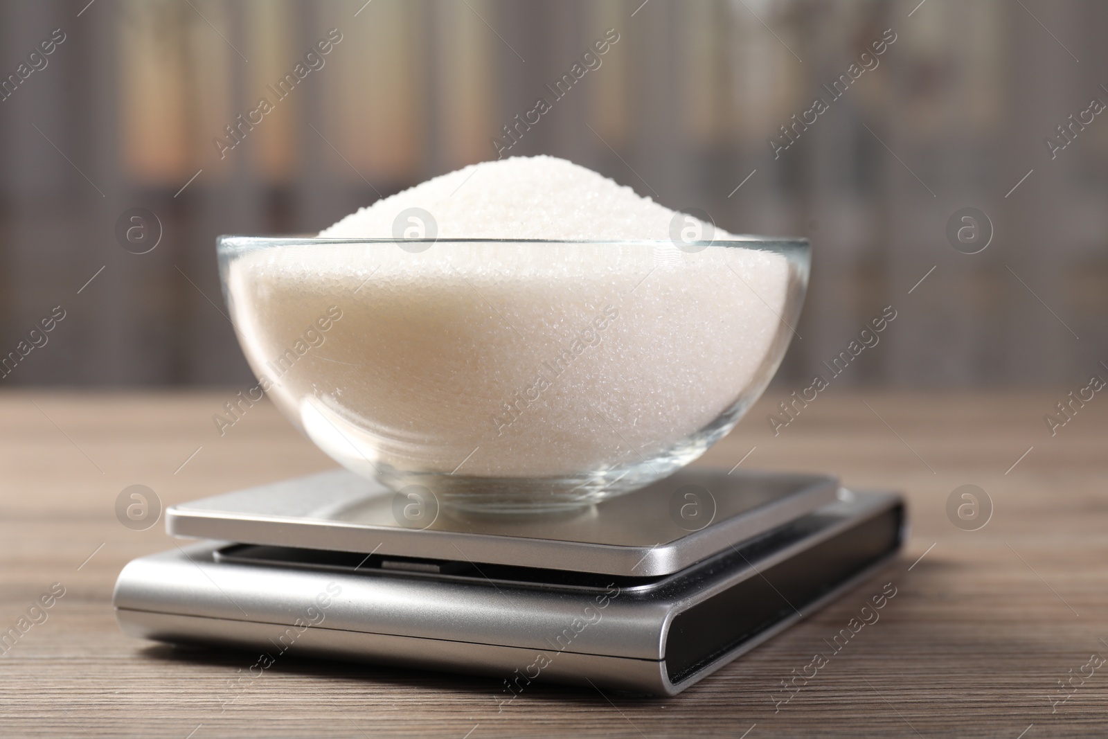 Digital kitchen scale with bowl of sugar on wooden table indoors, closeup Photo of Digital kitchen scale with bowl of sugar on wooden table indoors, closeup