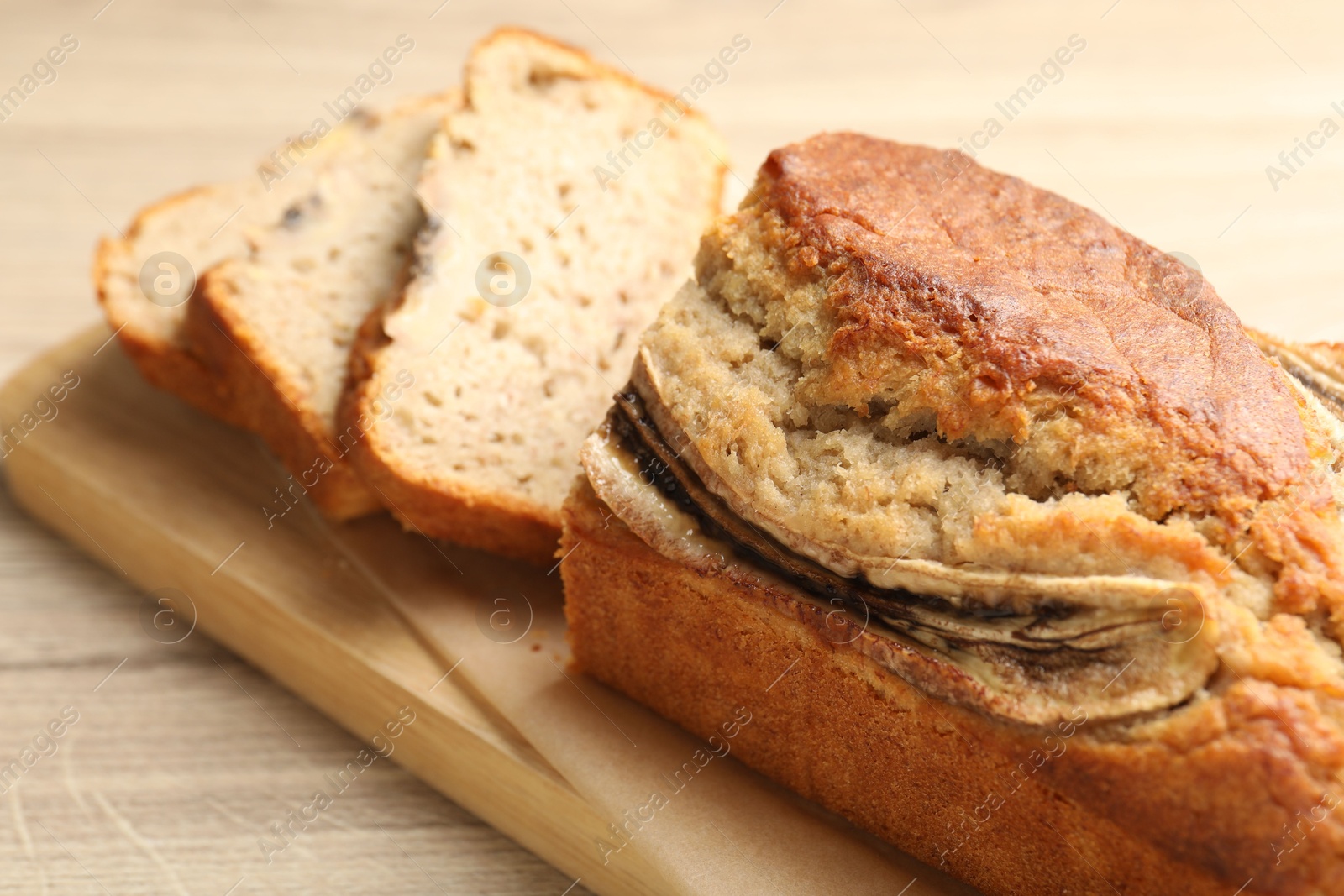 Photo of Cut banana bread on wooden table, closeup