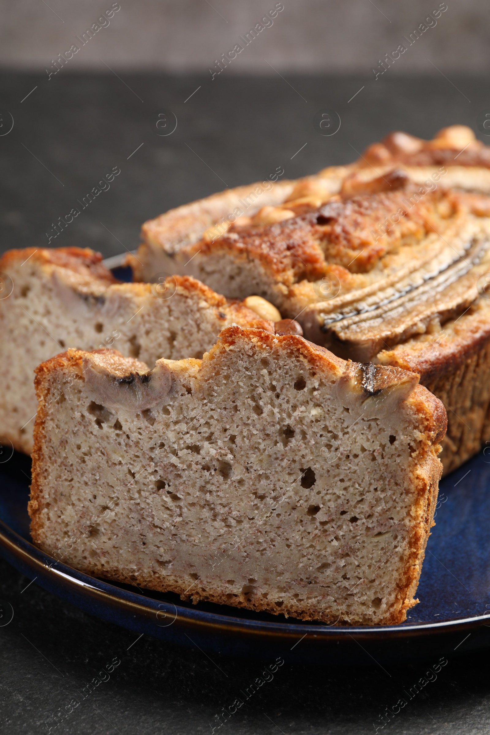 Cut banana bread with nuts on black table, closeup Photo of Cut banana bread with nuts on black table, closeup