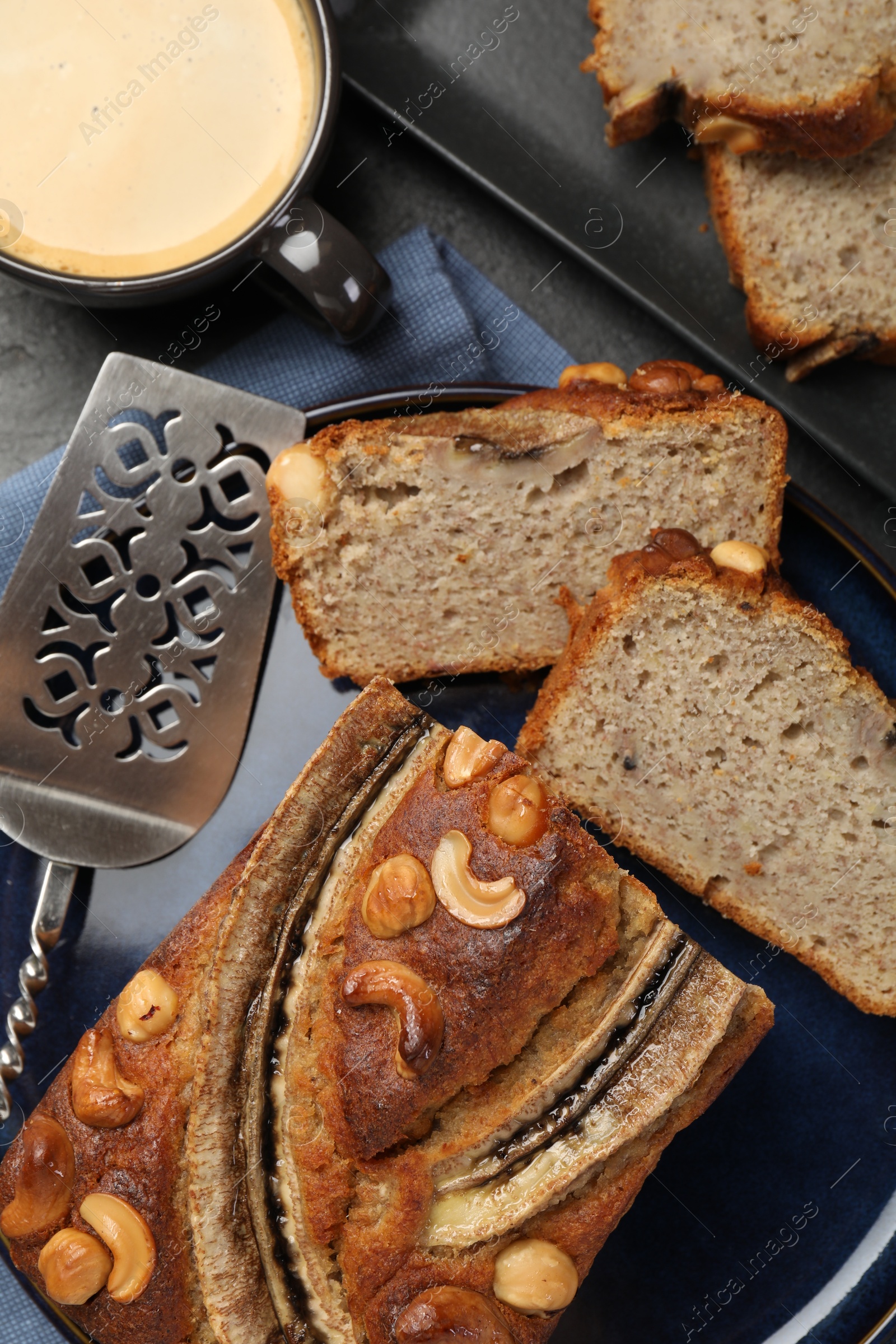 Cut banana bread with nuts, server and coffee on table, flat lay Photo of Cut banana bread with nuts, server and coffee on table, flat lay