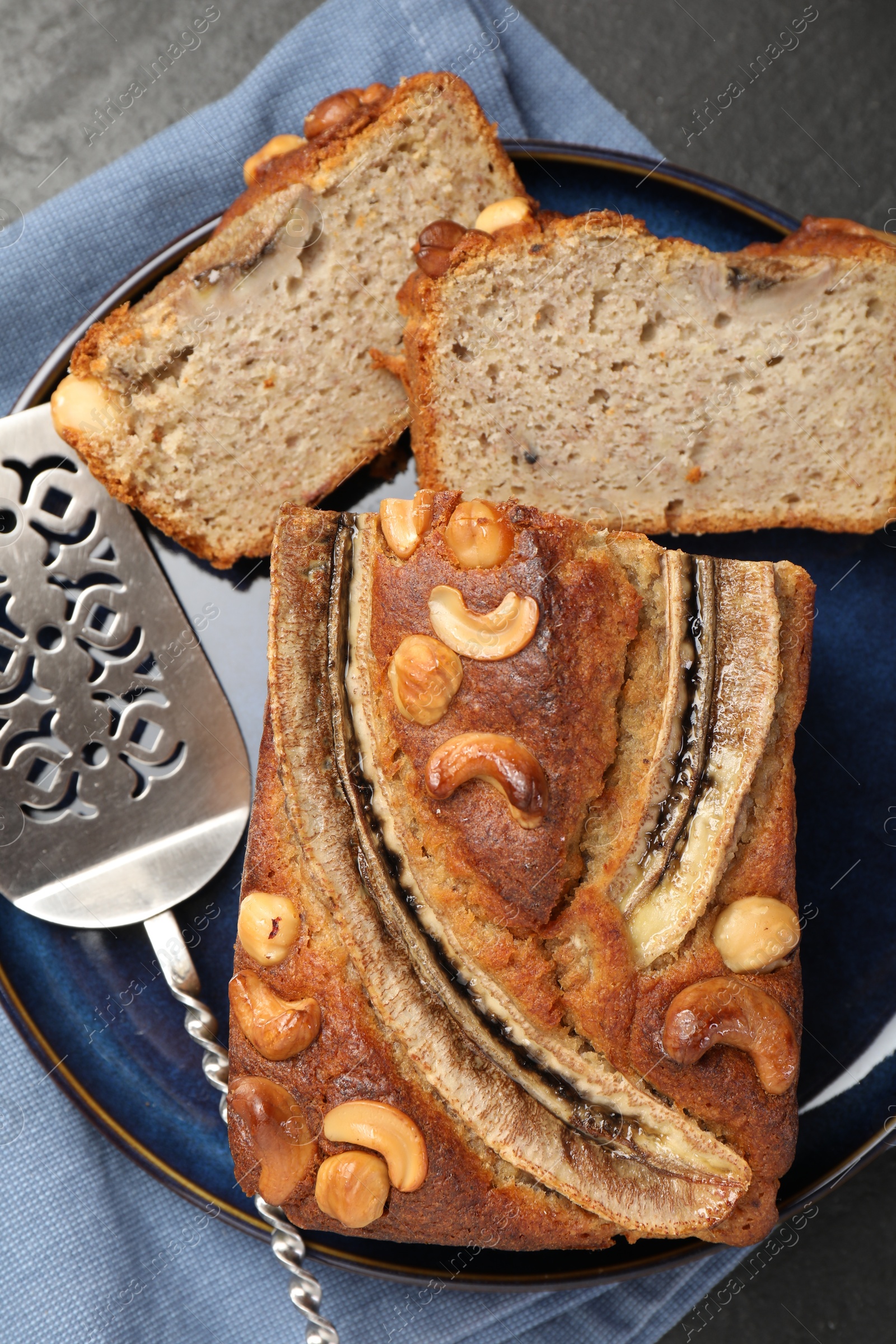 Cut banana bread with nuts server on black table, top view Photo of Cut banana bread with nuts server on black table, top view
