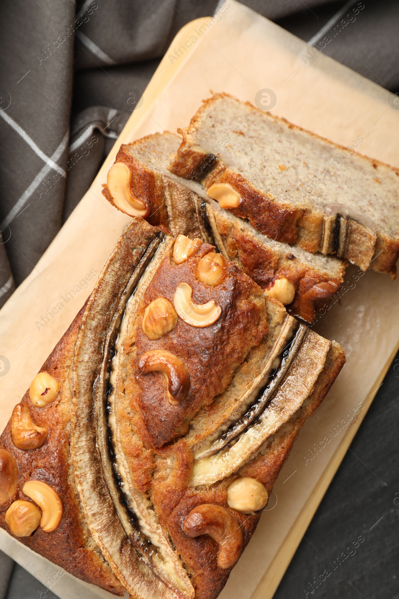 Cut banana bread with nuts on black table, top view Photo of Cut banana bread with nuts on black table, top view
