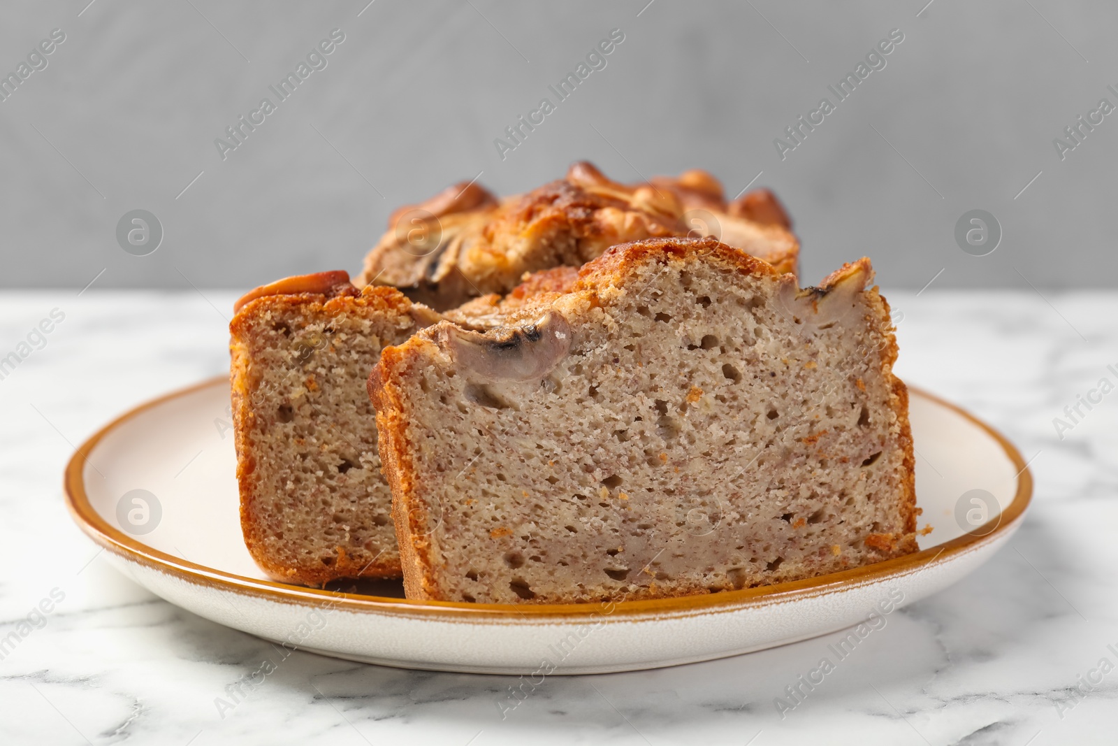 Cut banana bread with nuts on white marble table, closeup Photo of Cut banana bread with nuts on white marble table, closeup