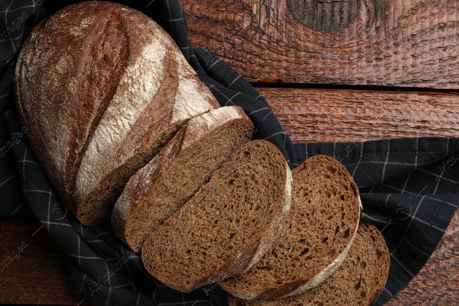 Photo of Pieces of fresh bread on wooden table, top view