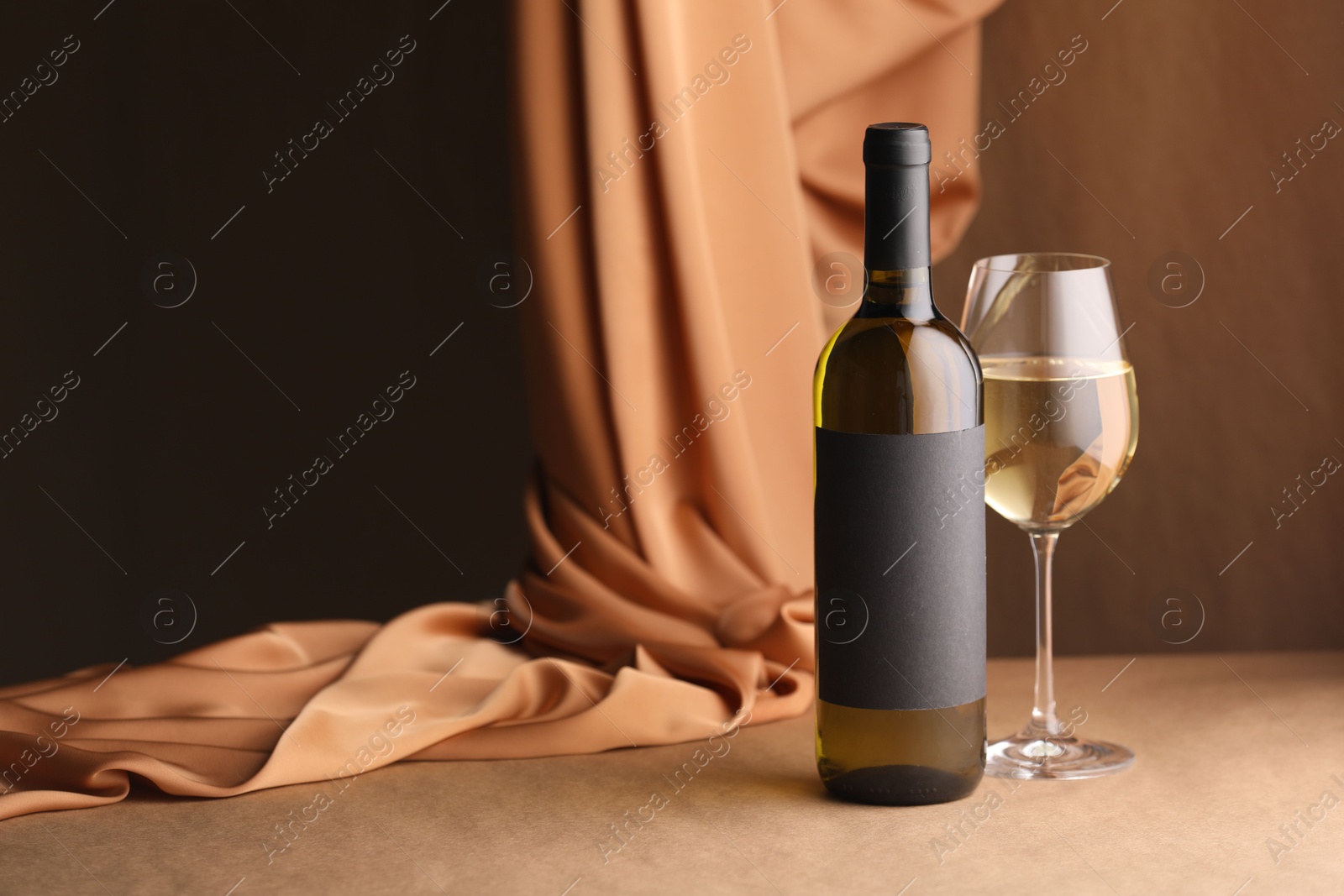 Bottle of wine, wineglass and cloth on brown table, space for text Photo of Bottle of wine, wineglass and cloth on brown table, space for text