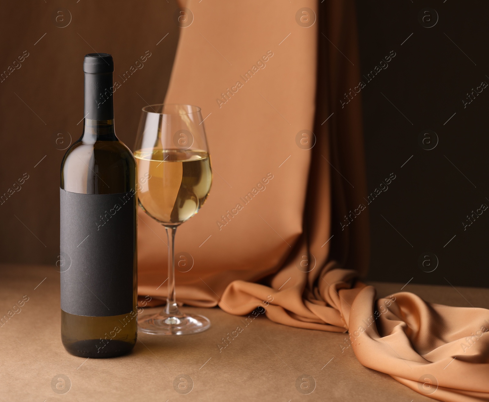 Bottle of wine, wineglass and cloth on brown table, space for text Photo of Bottle of wine, wineglass and cloth on brown table, space for text