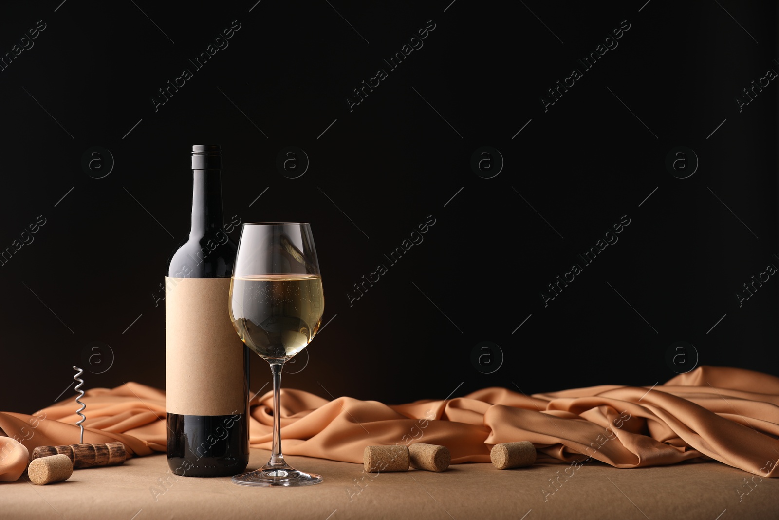 Bottle of wine, wineglass and cloth on brown table, space for text Photo of Bottle of wine, wineglass and cloth on brown table, space for text