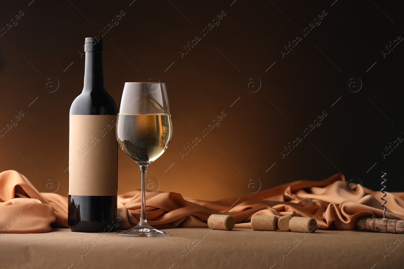 Bottle of wine, wineglass and cloth on brown table, space for text Photo of Bottle of wine, wineglass and cloth on brown table, space for text