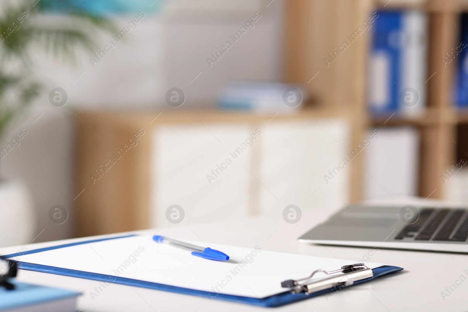 Doctor's workplace. Clipboard and pen on white table in medical office, closeup. Space for text Photo of Doctor's workplace. Clipboard and pen on white table in medical office, closeup. Space for text