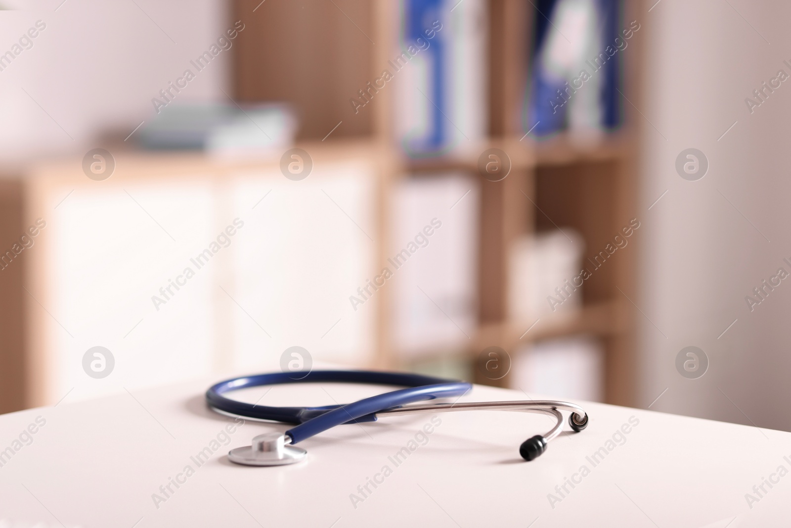 Doctor's workplace. Stethoscope on white table in medical office, closeup. Space for text Photo of Doctor's workplace. Stethoscope on white table in medical office, closeup. Space for text