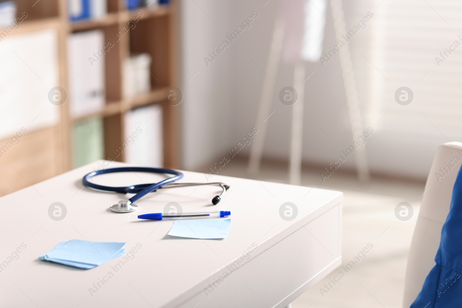 Doctor's workplace. Stethoscope, pen and sticky notes on white table in medical office, space for text Photo of Doctor's workplace. Stethoscope, pen and sticky notes on white table in medical office, space for text