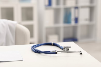 Photo of Doctor's workplace. Stethoscope on white table in medical office, closeup. Space for text
