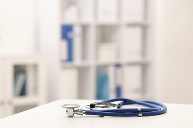 Photo of Doctor's workplace. Stethoscope on white table in medical office, closeup. Space for text
