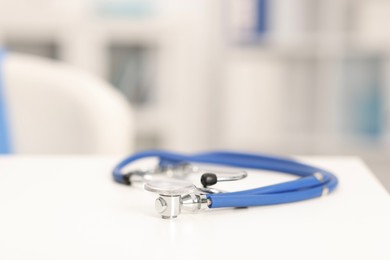 Photo of Doctor's workplace. Stethoscope on white table in medical office, closeup. Space for text