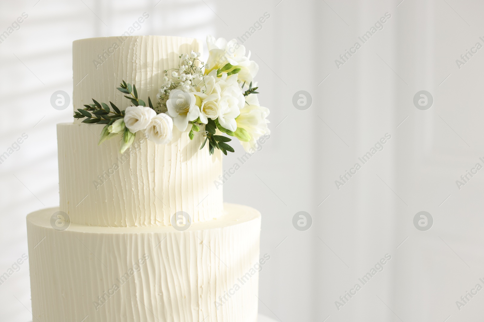Delicious wedding cake with floral decor indoors, closeup. Space for text Photo of Delicious wedding cake with floral decor indoors, closeup. Space for text