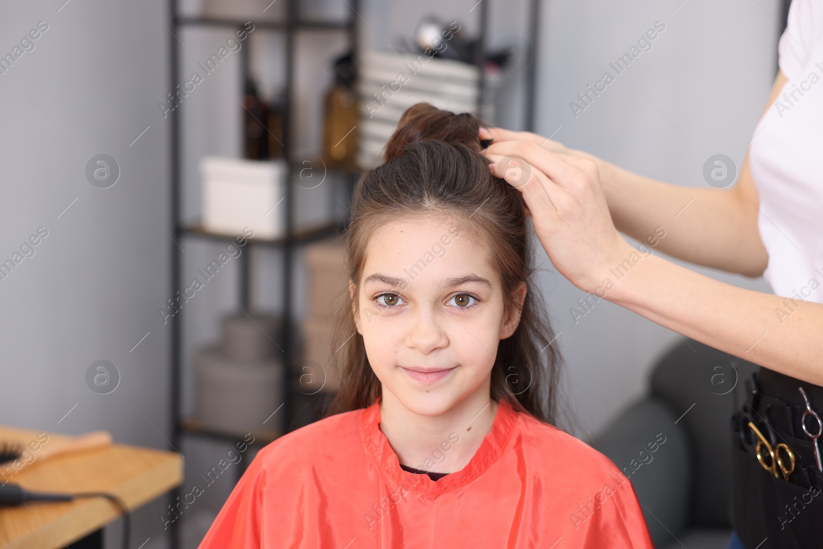 Hairdresser doing girl's hairstyle in salon, closeup Photo of Hairdresser doing girl's hairstyle in salon, closeup