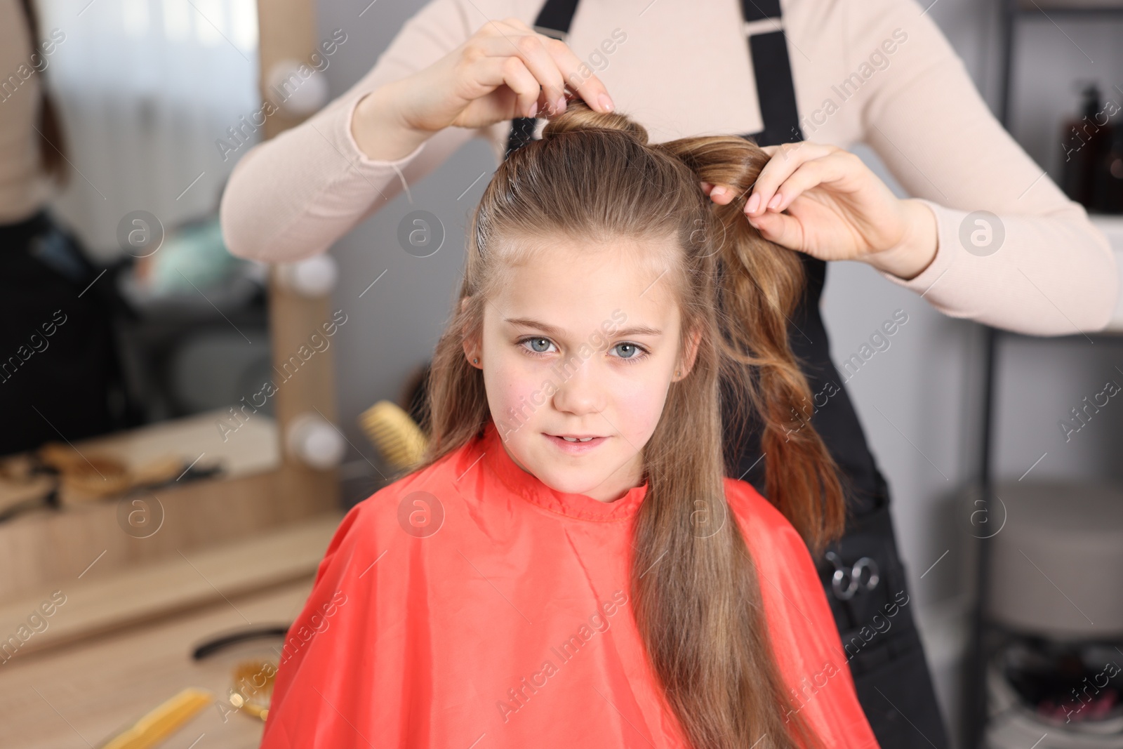 Hairdresser doing girl's hairstyle in salon, closeup Photo of Hairdresser doing girl's hairstyle in salon, closeup