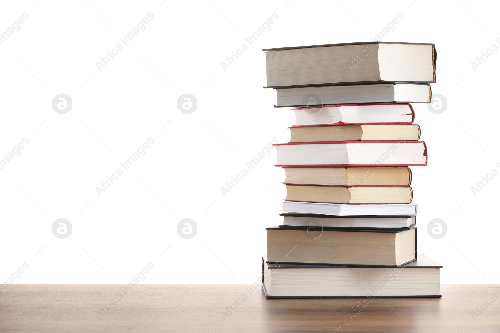 Stack of old books on wooden table against white background Photo of Stack of old books on wooden table against white background