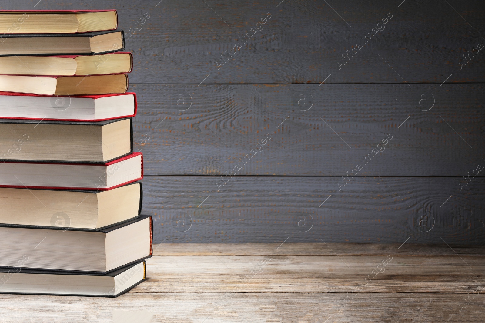 Stack of old books on wooden table, space for text Photo of Stack of old books on wooden table, space for text
