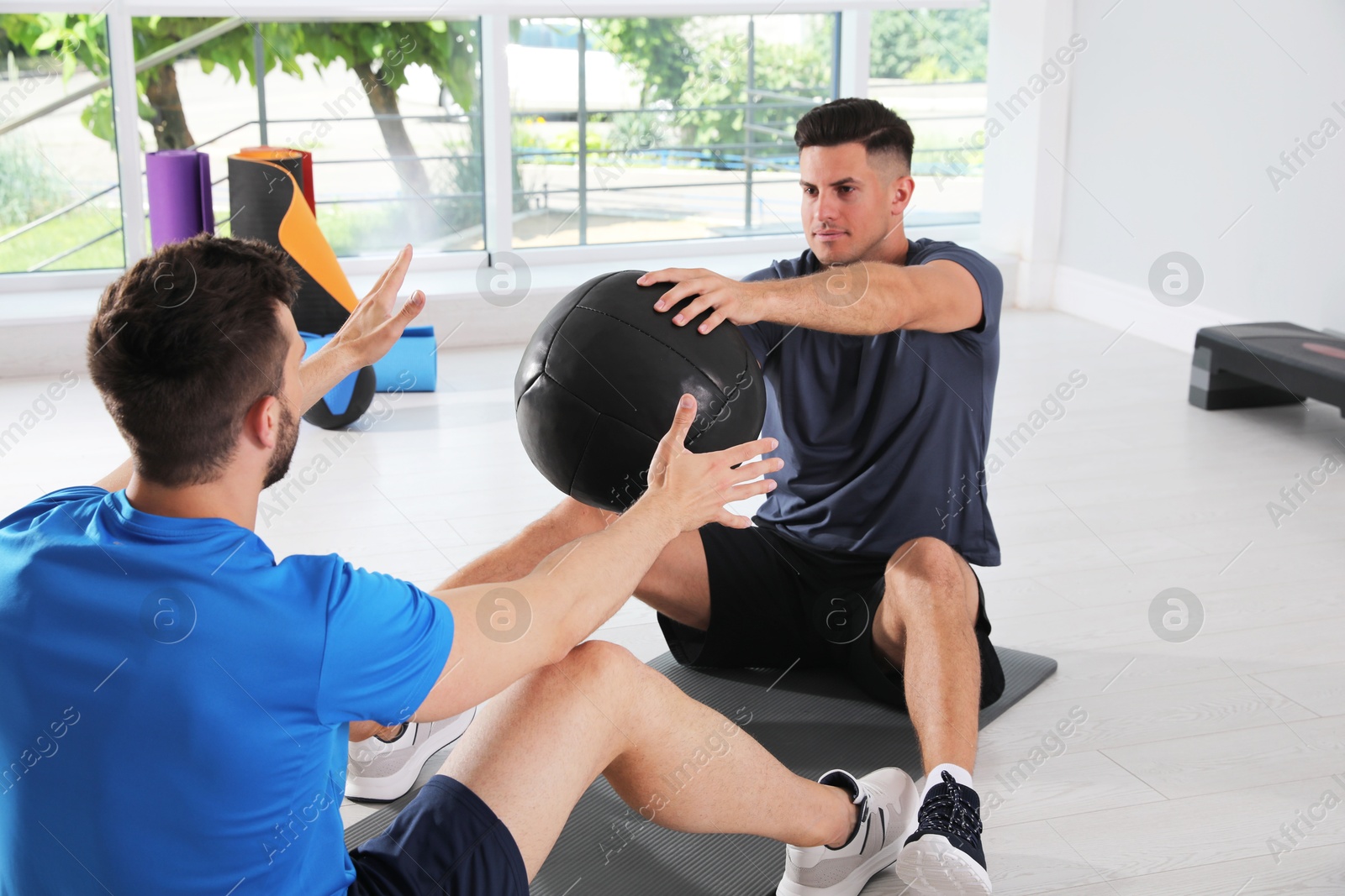 Muscular men exercising with medicine ball in modern gym Photo of Muscular men exercising with medicine ball in modern gym