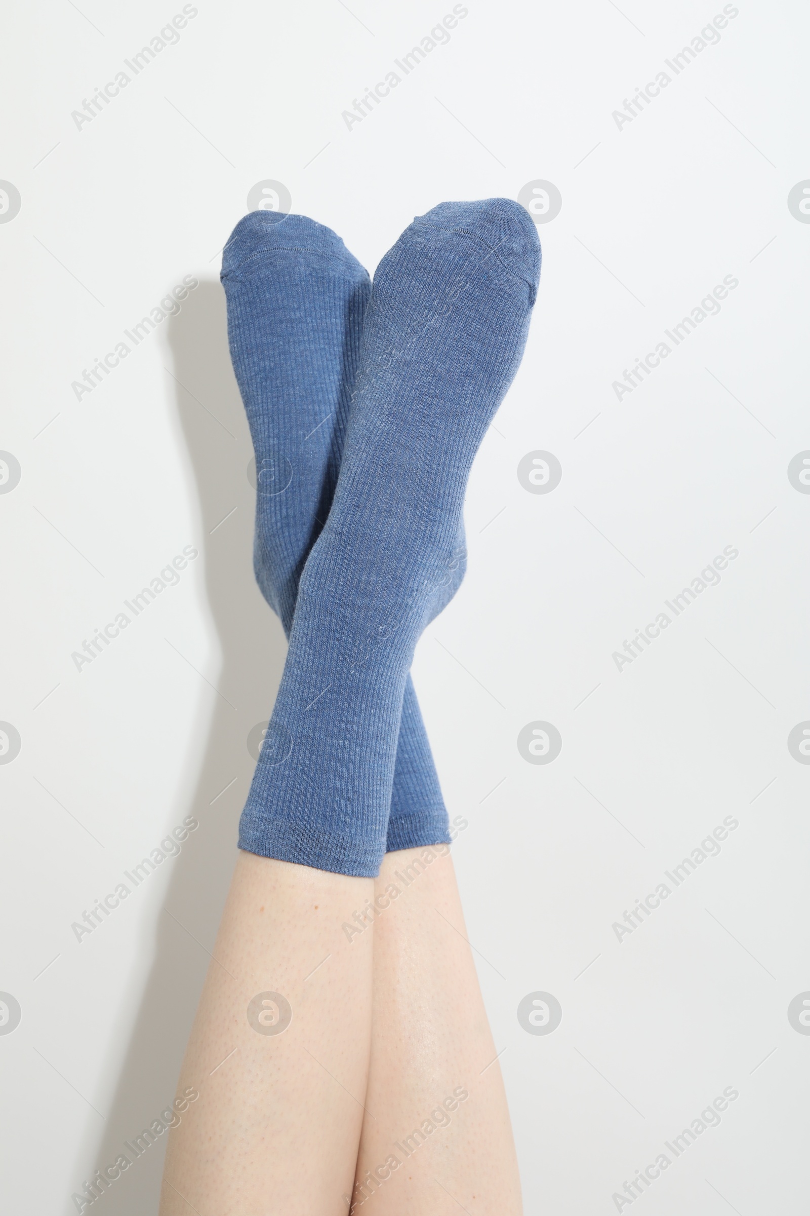 Woman in blue socks on light background, closeup Photo of Woman in blue socks on light background, closeup