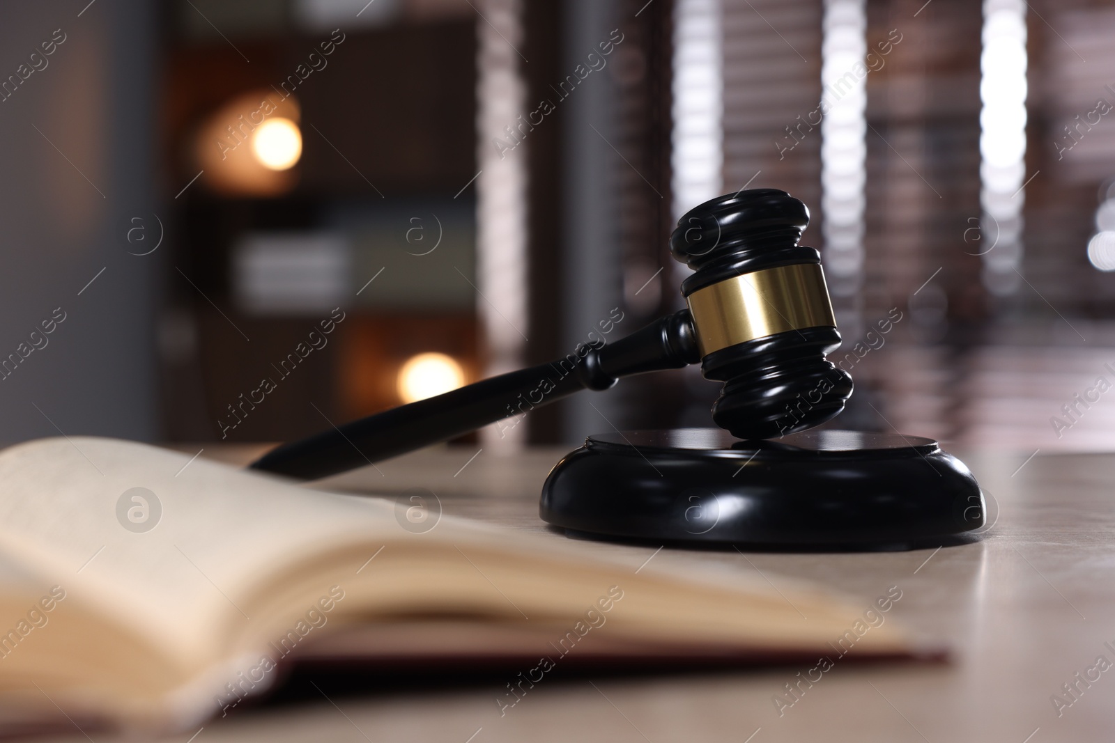 Judge's gavel, sound block and book on table against blurred background, selective focus Photo of Judge's gavel, sound block and book on table against blurred background, selective focus