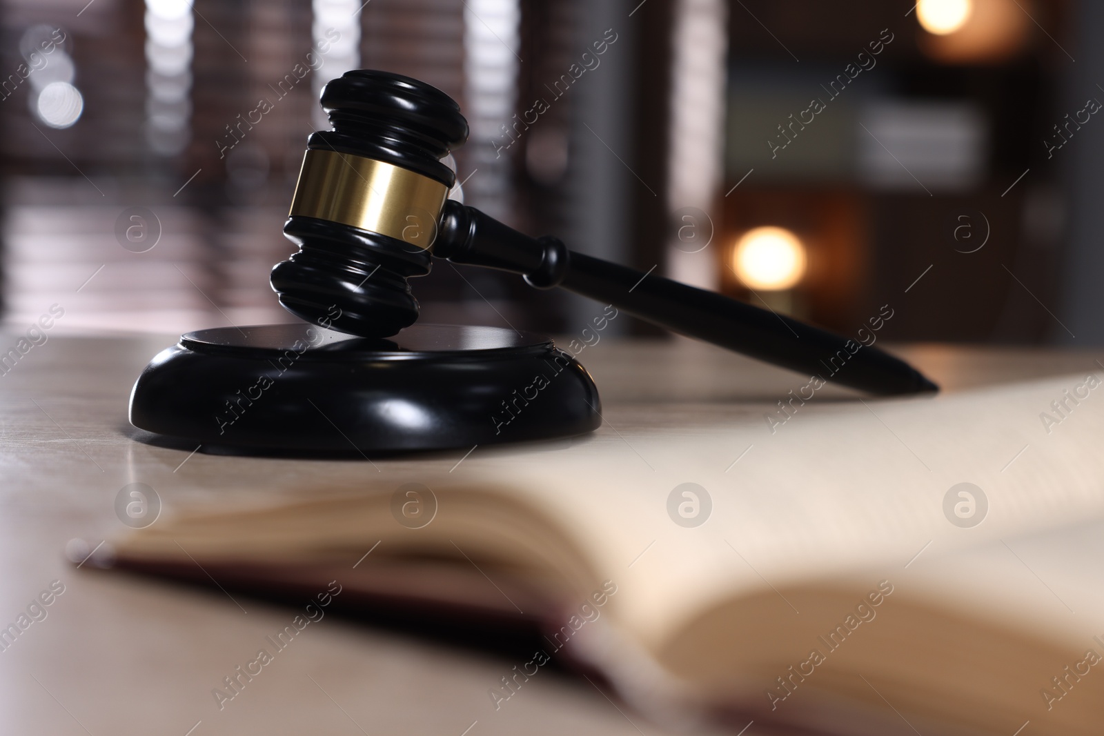 Judge's gavel, sound block and book on table against blurred background, selective focus Photo of Judge's gavel, sound block and book on table against blurred background, selective focus