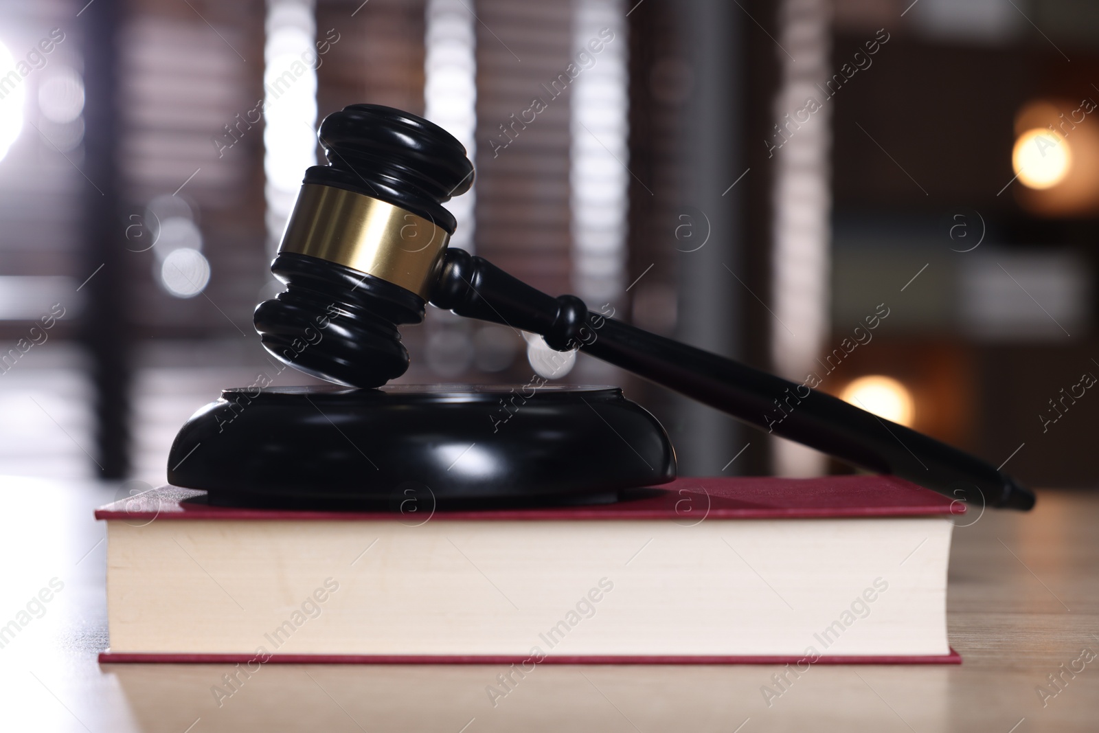 Judge's gavel, sound block and book on wooden table against blurred background, closeup Photo of Judge's gavel, sound block and book on wooden table against blurred background, closeup