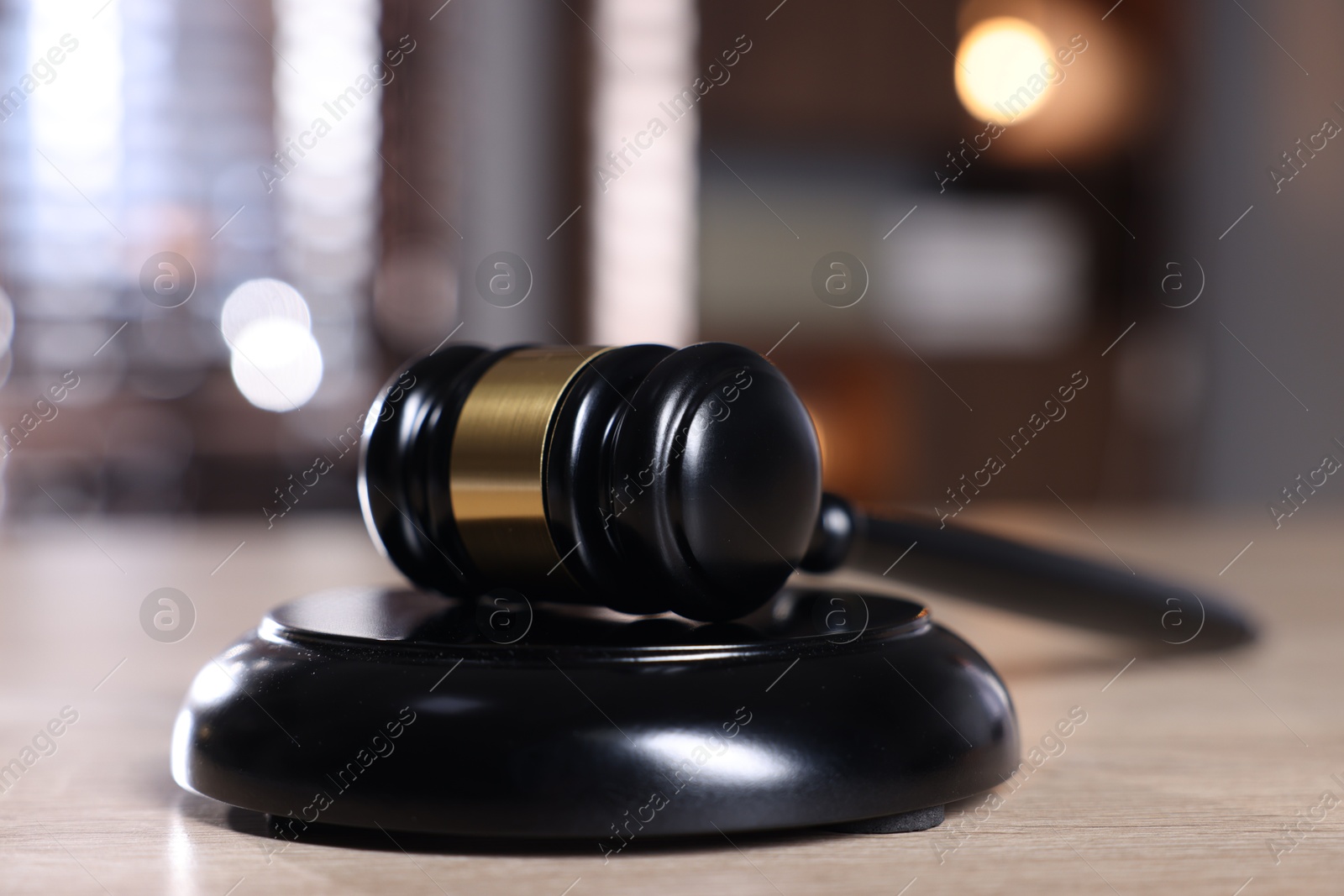 Judge's gavel and sound block on wooden table against blurred background, closeup Photo of Judge's gavel and sound block on wooden table against blurred background, closeup