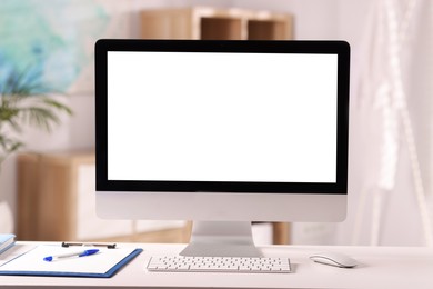 Photo of Doctor's workplace. Computer monitor, keyboard, mouse and stationery on white table in medical office