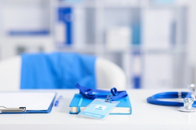 Photo of Doctor's workplace with stethoscope and paperwork on desk, closeup. Space for text