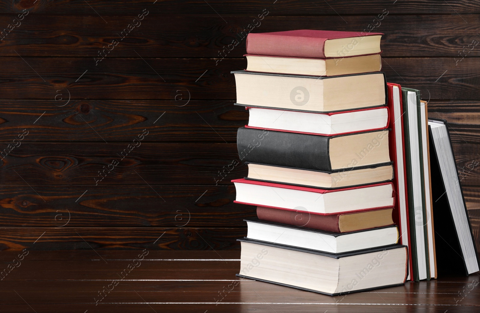 Stack of old books on wooden table, space for text Photo of Stack of old books on wooden table, space for text