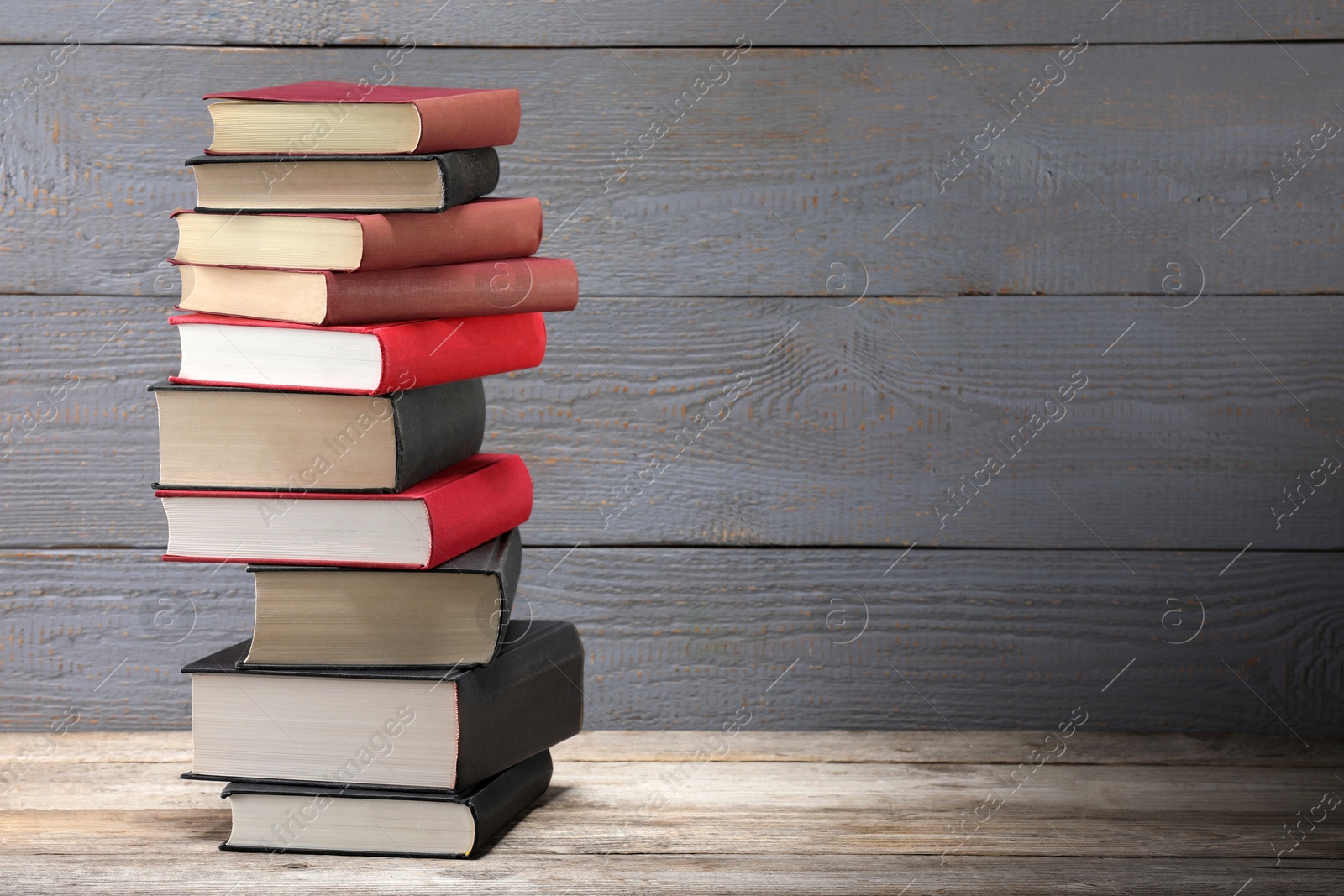 Stack of old books on wooden table, space for text Photo of Stack of old books on wooden table, space for text