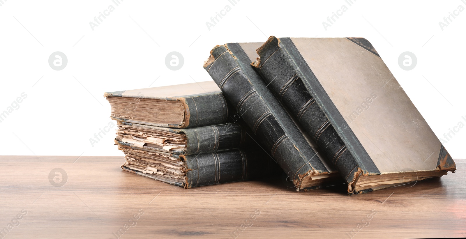 Old books on wooden table against white background Photo of Old books on wooden table against white background