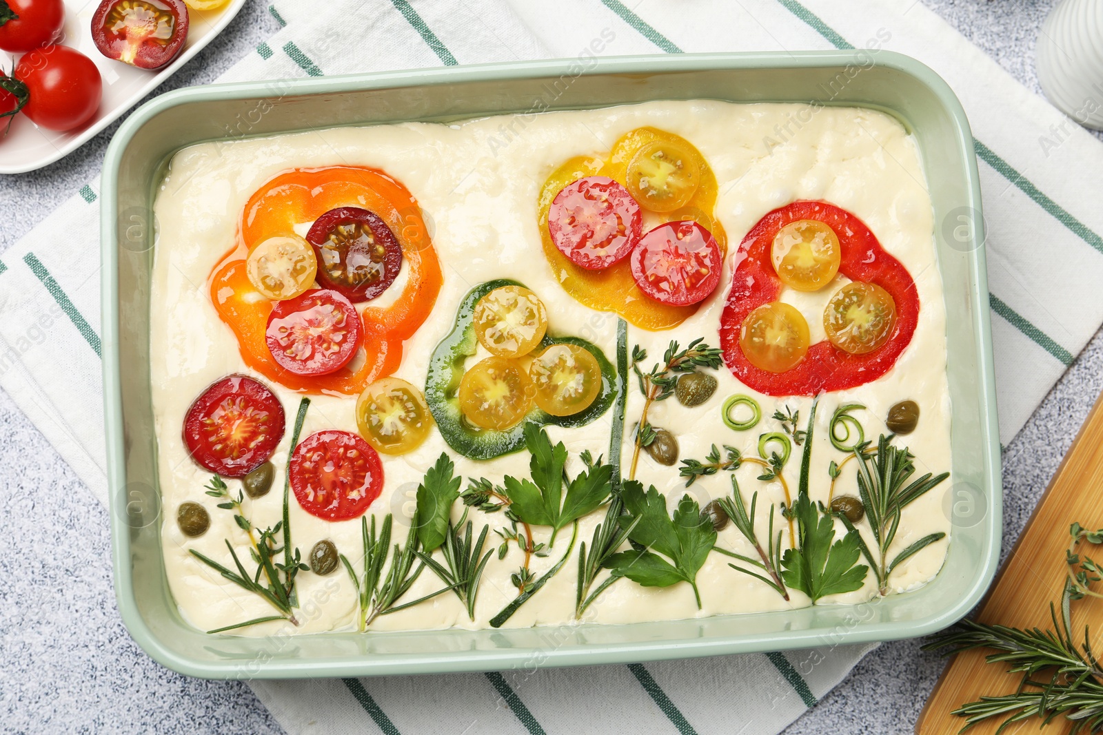 Raw focaccia with vegetables and spices on light grey table, flat lay Photo of Raw focaccia with vegetables and spices on light grey table, flat lay