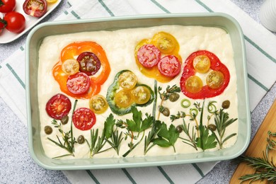 Photo of Raw focaccia with vegetables and spices on light grey table, flat lay