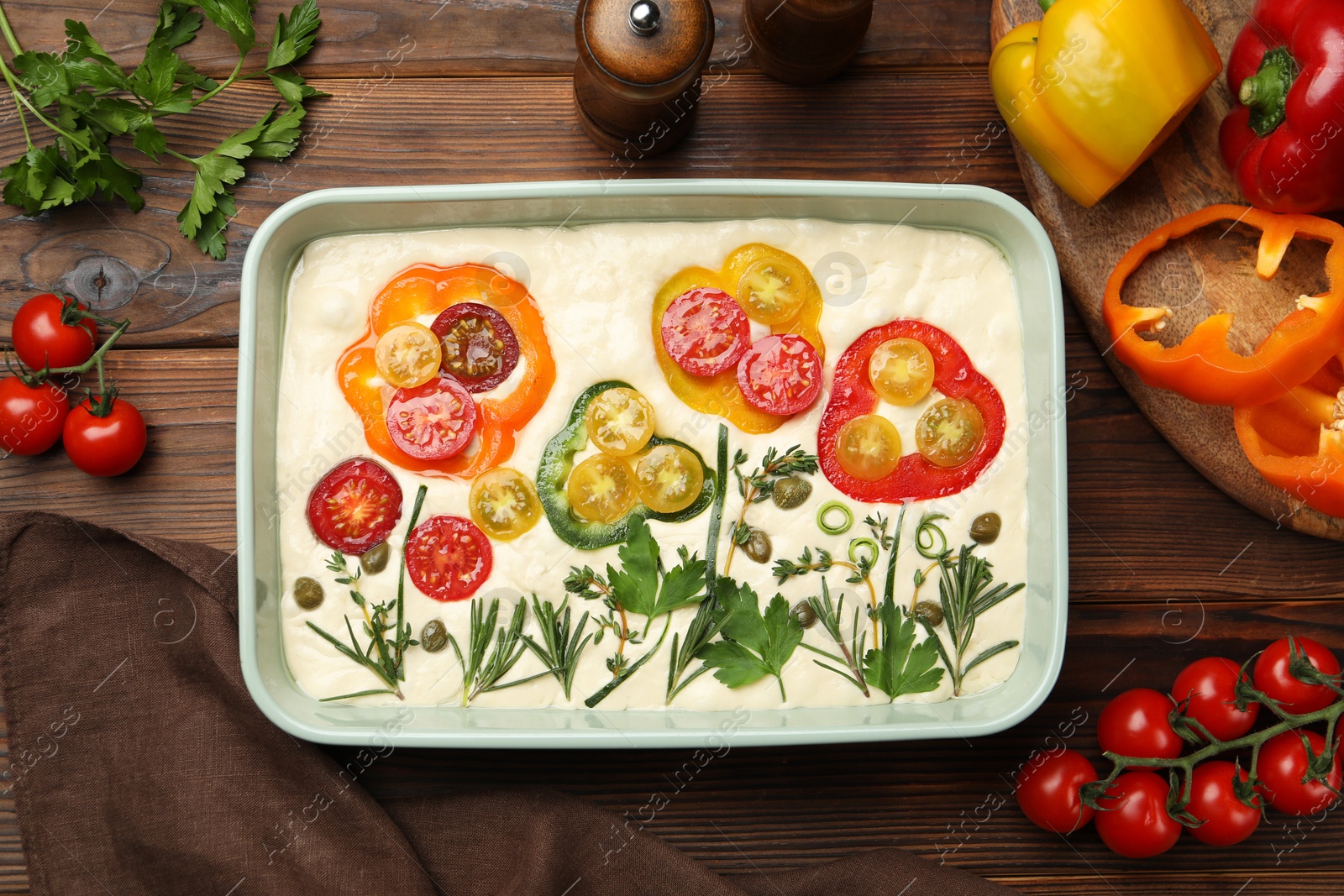 Raw focaccia with vegetables and spices on wooden table, flat lay Photo of Raw focaccia with vegetables and spices on wooden table, flat lay