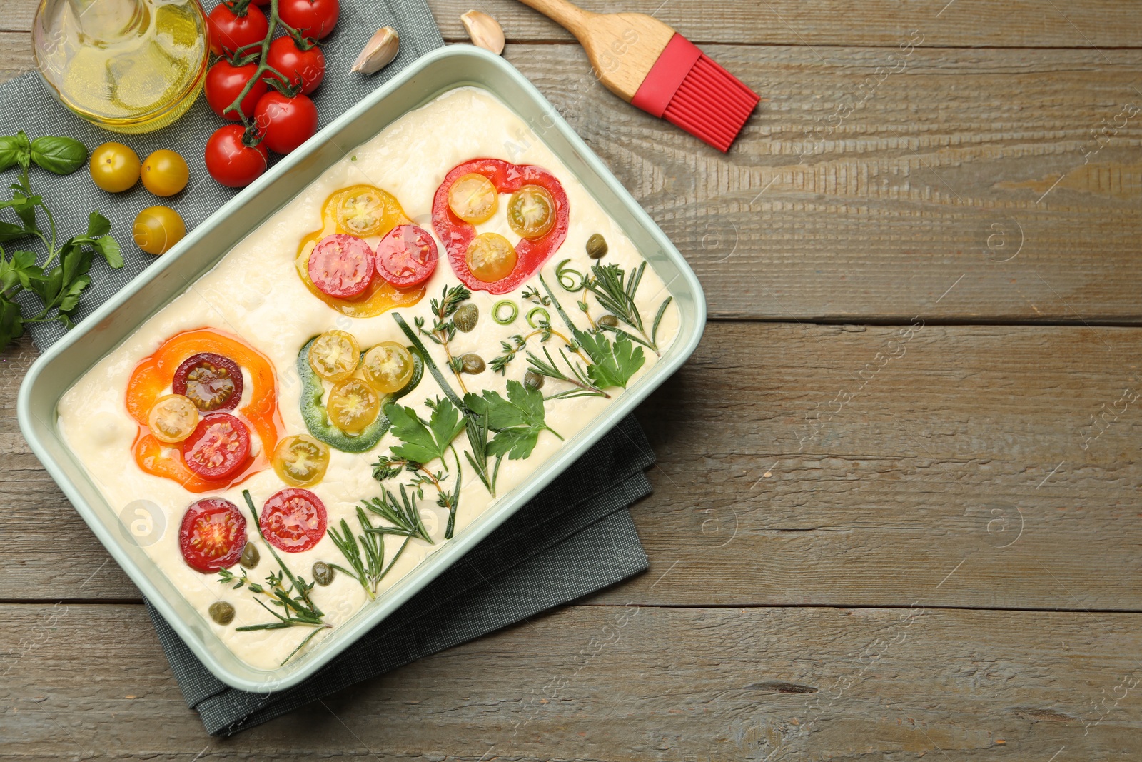 Raw focaccia with vegetables, spices and brush on wooden table, flat lay. Space for text Photo of Raw focaccia with vegetables, spices and brush on wooden table, flat lay. Space for text