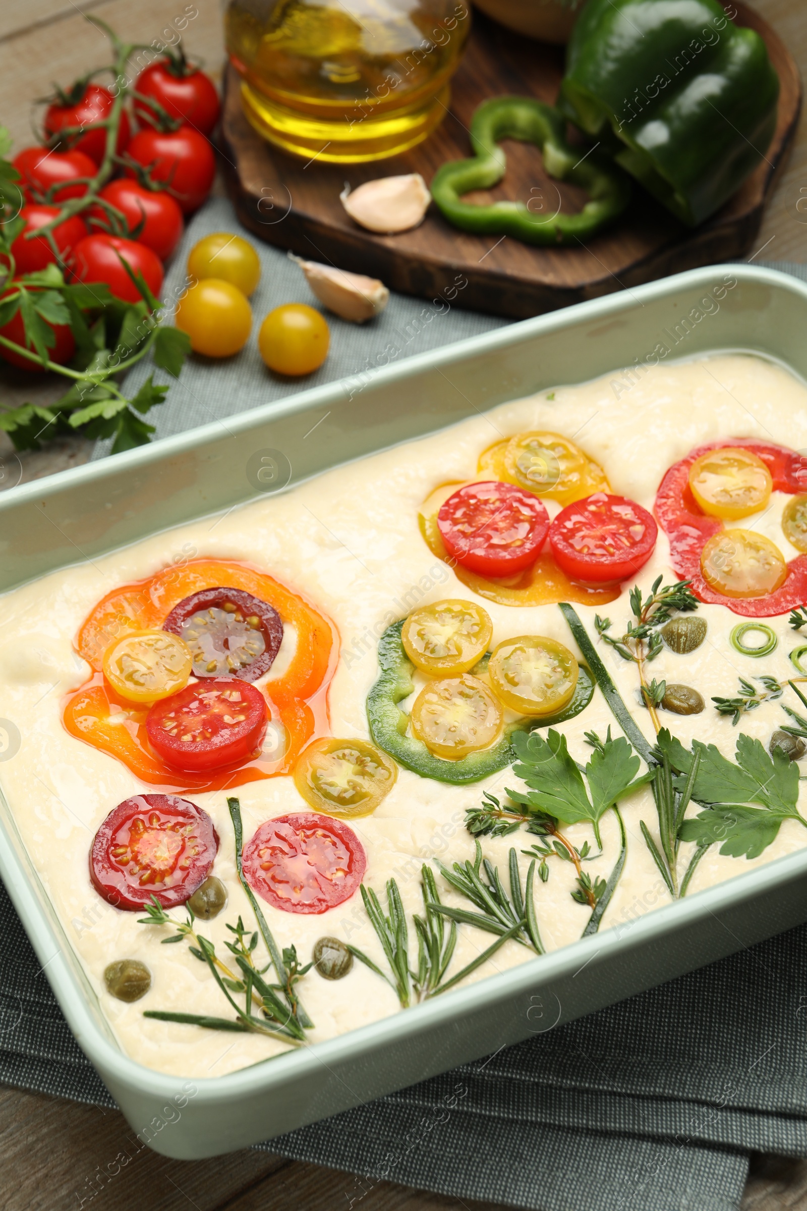Raw focaccia with vegetables and spices on table, closeup Photo of Raw focaccia with vegetables and spices on table, closeup