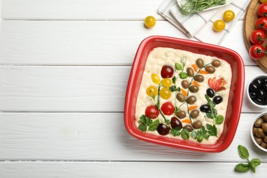 Photo of Raw focaccia with vegetables, olives and spices on white wooden table, flat lay. Space for text